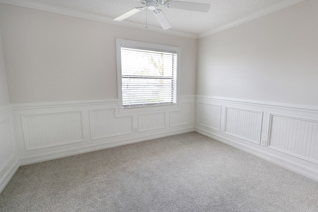 A room with a window and a ceiling fan.